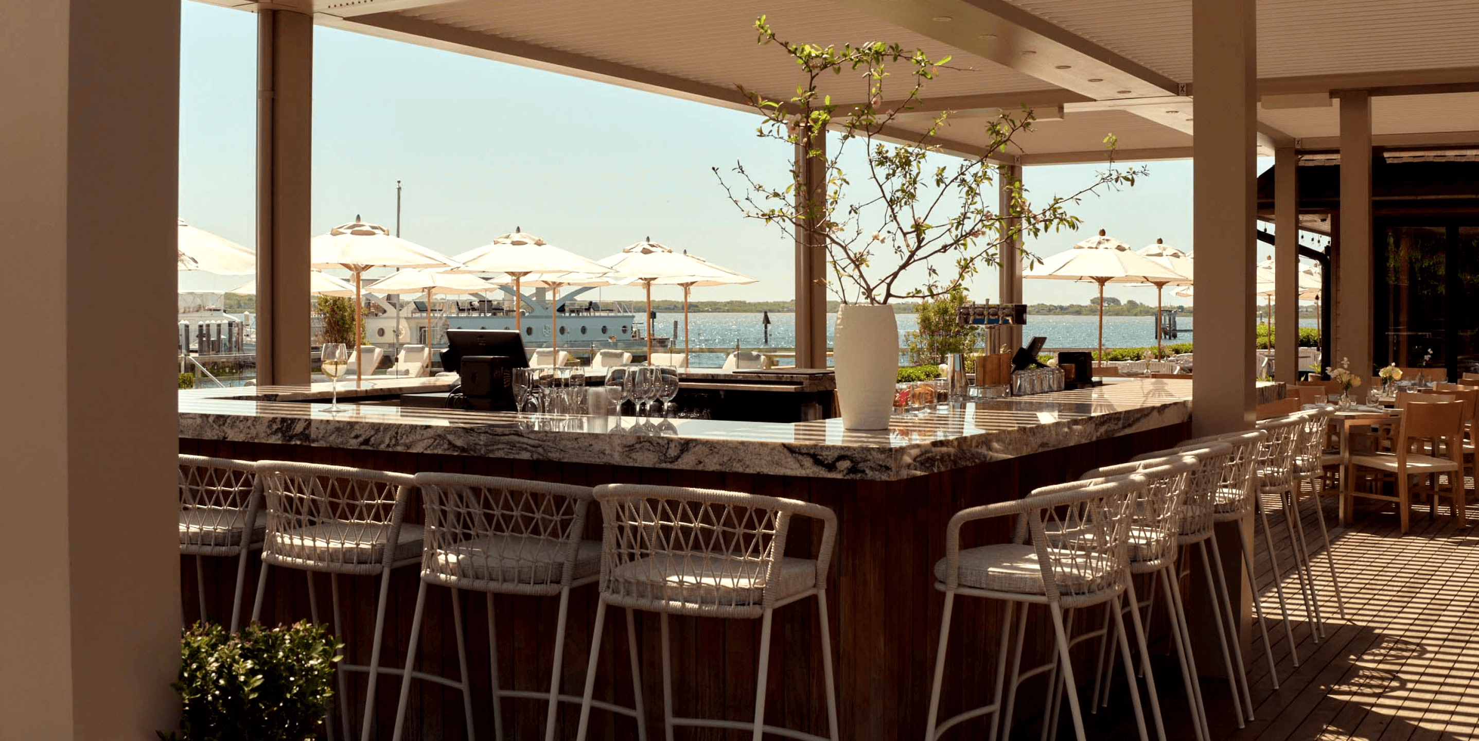 Long chairs positioned beside the bar counter offer a stunning view of the sea.