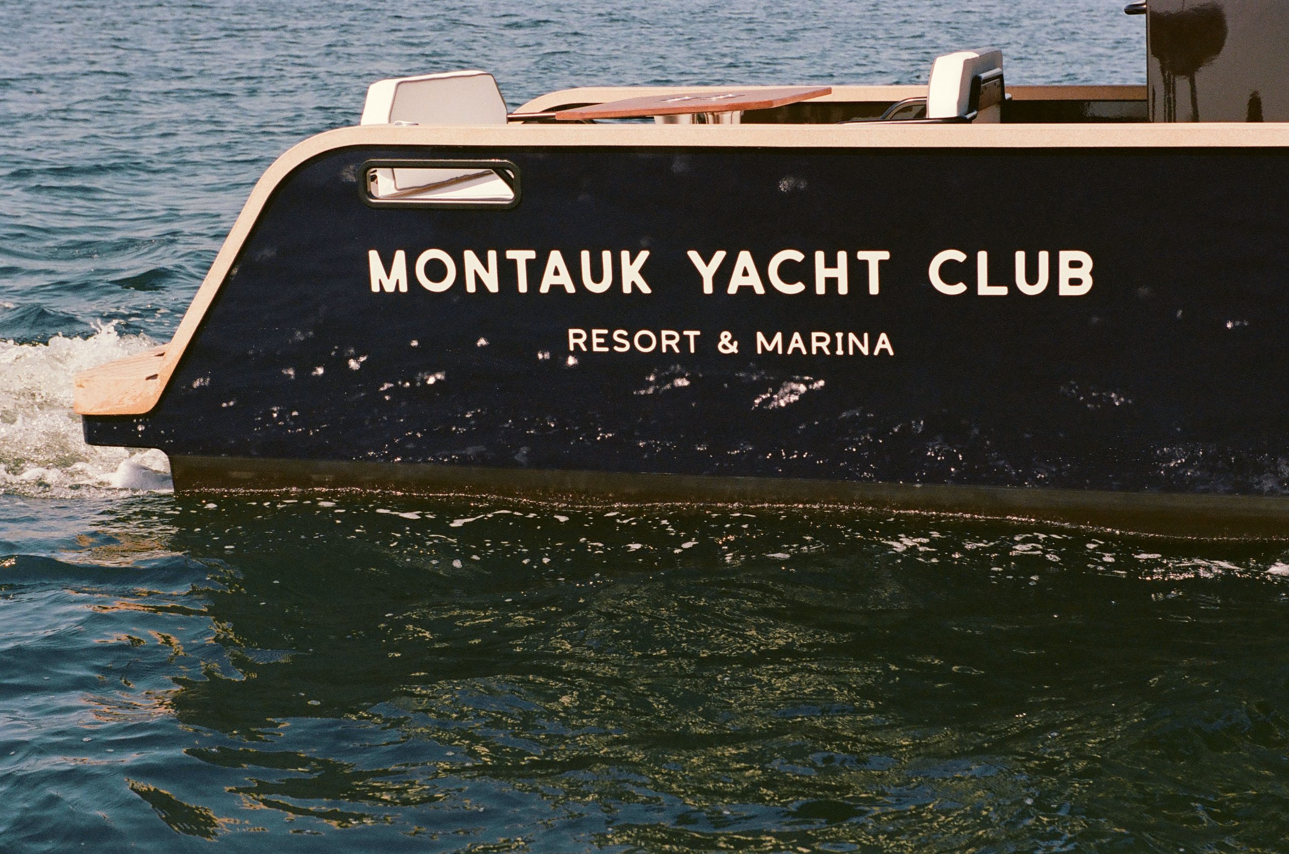A yacht named "MONTAUK YACHT CLUB - RESORT & MARINA" rolls on the sea.