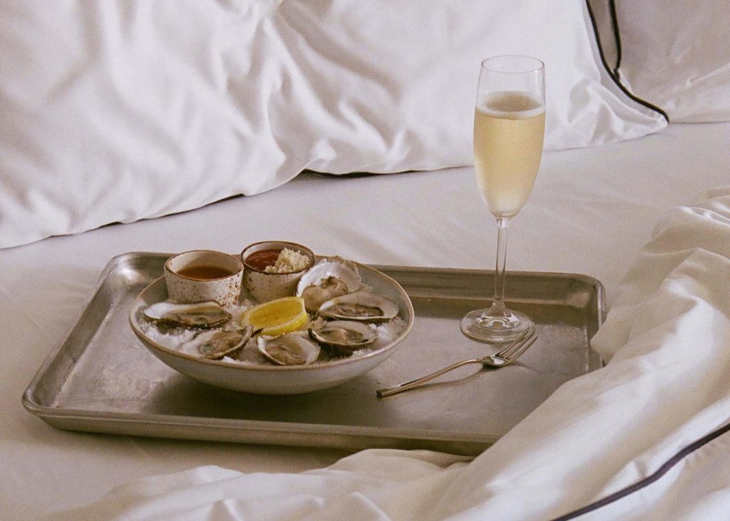 A delectable seafood breakfast, elegantly served with a wine glass on the bed.