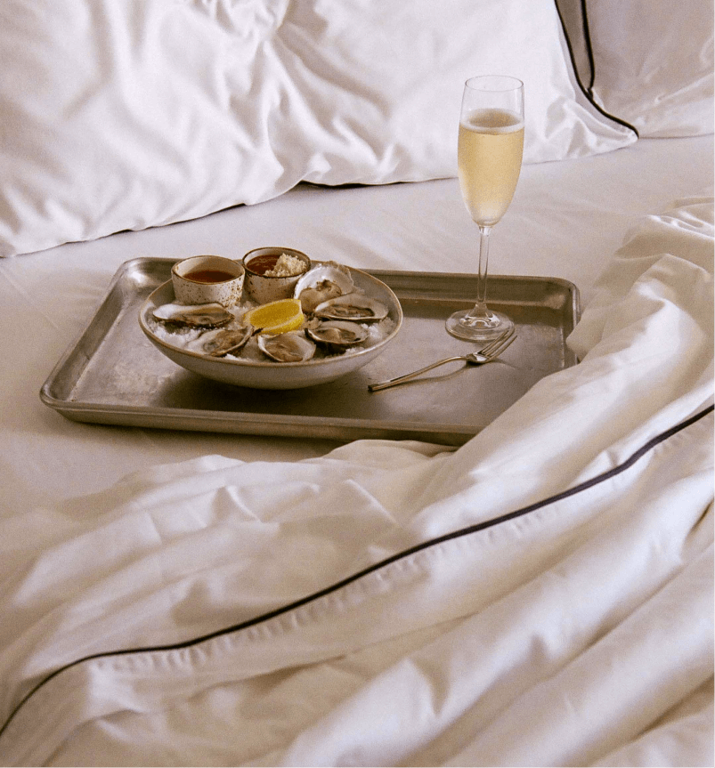 A delicious seafood breakfast with a wine glass served elegantly on the bed.
