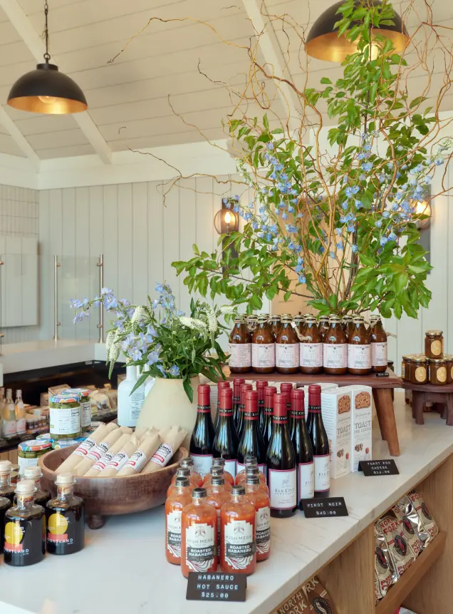 Various types of products are displayed on tables in the shop for customers.