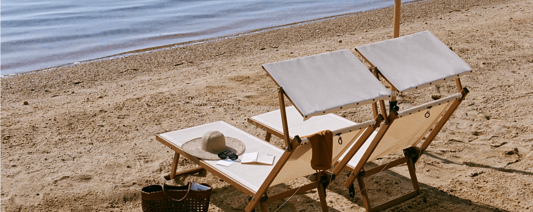 Two lounge chairs positioned by the seashore provide a splendid view of the sea.