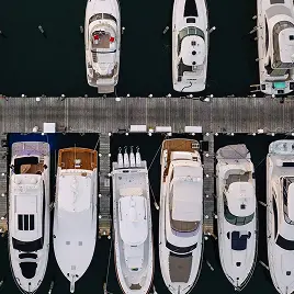 Aerial view of docked yachts lined along marina pier