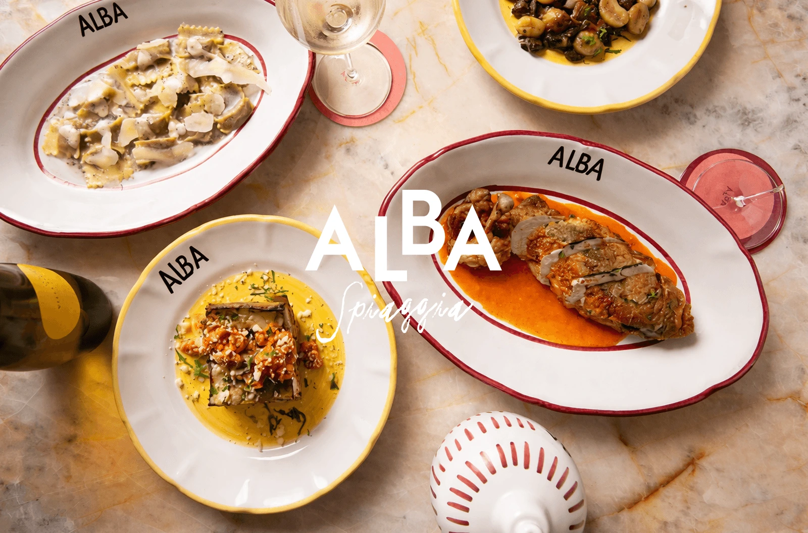 Assorted plated Italian dishes with wine on marble table at Alba restaurant